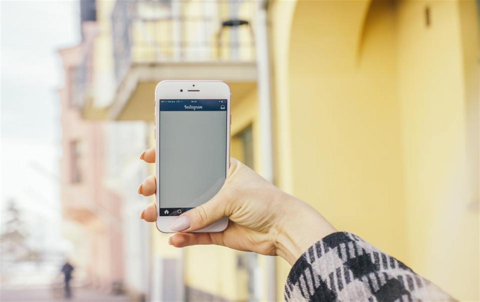 Mano sosteniendo un teléfono móvil en la calle